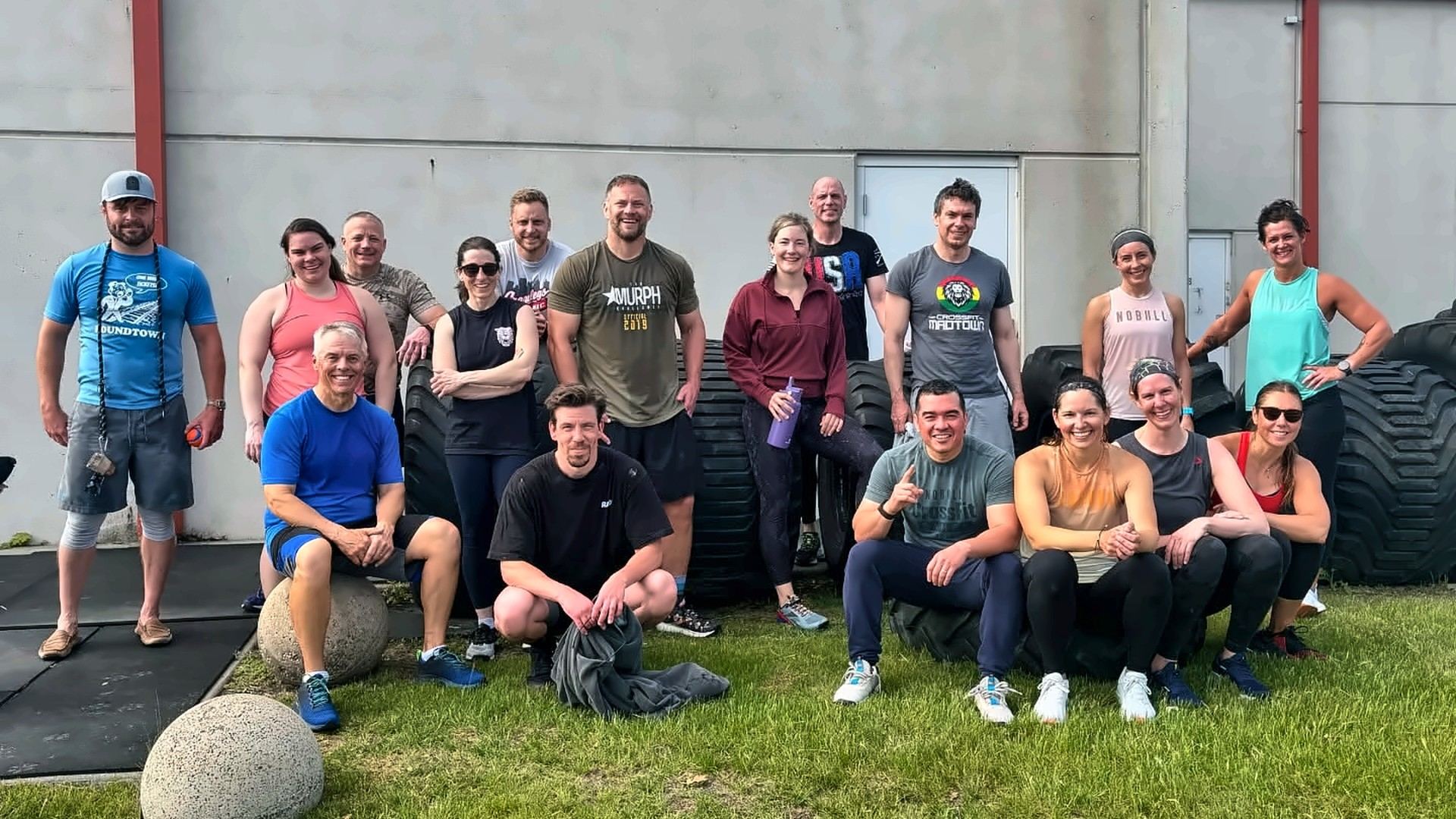 A group of MadCity members gathered on the grass outside the gym
